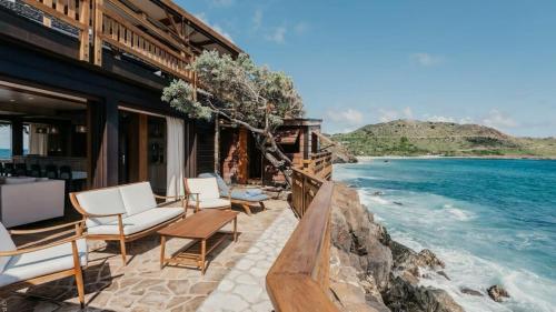 a house on the beach with chairs and the ocean at Unique Villa Offering Vast Spaces in Toiny