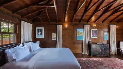 a bedroom with a large bed in a room with windows at Unique Villa Offering Vast Spaces in Toiny