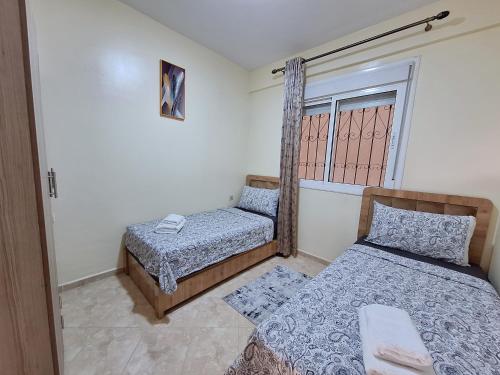 a bedroom with two beds and a window at Cool Family Apartment 2Chambres Balcon,WiFi,Tanger in Tangier