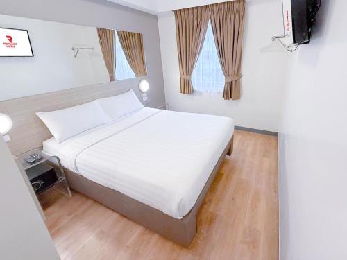 a bedroom with a large white bed and a window at Red Planet Manila Aseana City in Manila