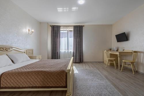 a hotel room with a bed and a table and a desk at Premium hotel & SPA in Bukovel
