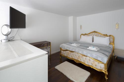 ein Schlafzimmer mit einem Bett und einem Schreibtisch mit einem Fernseher in der Unterkunft Skau 3 Eurovea Danube View Free Parking in Bratislava