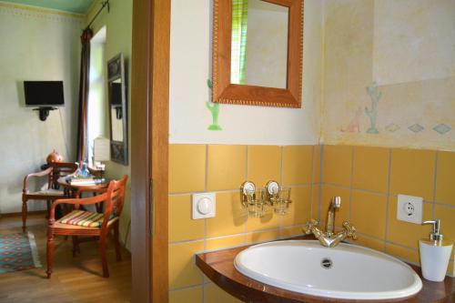 ein Badezimmer mit einem Waschbecken, einem Spiegel und einem Stuhl in der Unterkunft Gottesgabe in Rheine