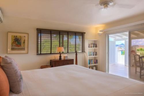 a bedroom with a large white bed and a window at Fresh Summer Villa with Superb View of the Hills in Quartier de Lorient