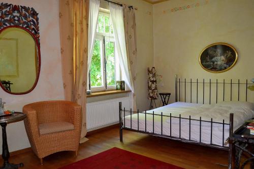a bedroom with a bed and a chair and a mirror at Gottesgabe in Rheine