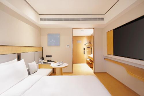a hotel room with a flat screen tv at Ji Hotel Orchard Singapore in Singapore