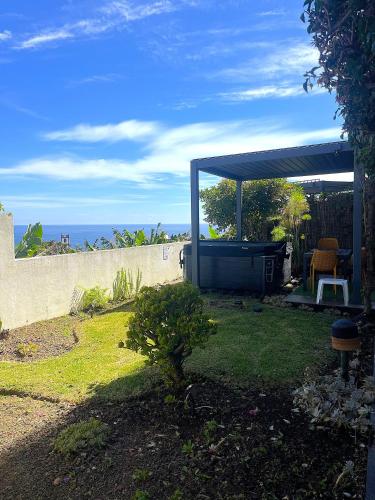 a backyard with a gazebo with the ocean in the background at epicenter LAGOA in Lagoa