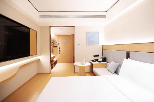 a hotel room with a bed and a flat screen tv at Ji Hotel Orchard Singapore in Singapore