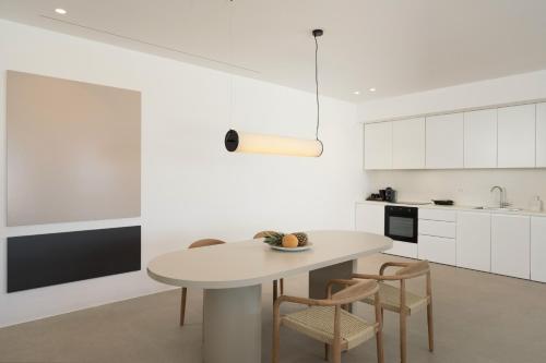a white kitchen with a table and chairs at Lilium Homes in Karterados