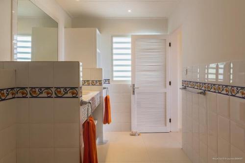 a bathroom with a shower and a sink and a door at Fresh Summer Villa with Superb View of the Hills in Quartier de Lorient
