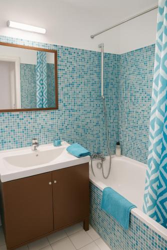 une salle de bain avec un lavabo, une baignoire et un miroir dans l'établissement Place Toscane, 8P, Fibre et Parking à Disneyland, à Serris