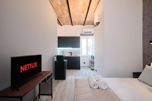 un salon avec un lit et une télévision dans l'établissement Circo Massimo Suite - In the heart of Testaccio, à Rome