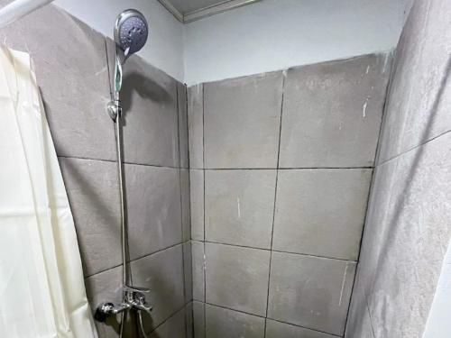 a shower with a shower head in a bathroom at RedDoorz Syariah at Budget Guesthouse Sepaku in Sepaku