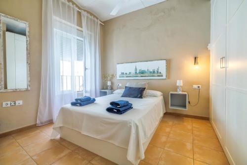 une chambre avec un lit avec des serviettes bleues dessus dans l'établissement Aromas de Especieros, à Cordoue