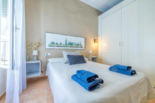 - une chambre avec un lit blanc et des serviettes bleues dans l'établissement Aromas de Especieros, à Cordoue