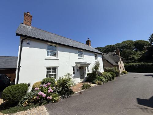 a white house with a driveway at The White House in West Lulworth