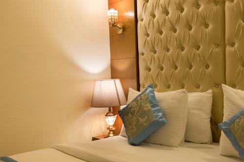 a bedroom with a bed with a headboard and a lamp at VIVVA Premier Delhi Aerocity FREE Airport Pick Up in New Delhi