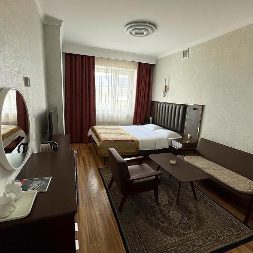 a hotel room with a bed and a table at Evergreen Hotel in Ulaanbaatar
