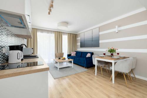 Una cocina y una sala de estar con un sofá azul. en Nadmorski Apartament w Pobierowie z Parkingiem oraz Basenem by Noclegi Renters, en Pobierowo