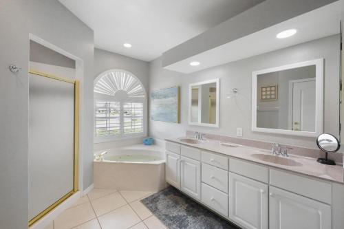 a bathroom with two sinks and a bath tub at 100 Bonita Court in Marco Island