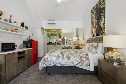 a bedroom with a bed and a kitchen at Private Suite Nautilus Beach Front Resort in Coffs Harbour