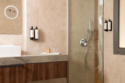 a bathroom with a shower with a glass door at KRESTEN ROYAL Euphoria Resort in Kallithea Rhodes