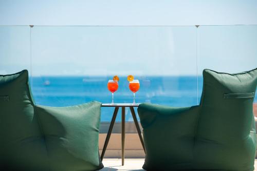 two wine glasses sitting on a table next to two pillows at KRESTEN ROYAL Euphoria Resort in Kallithea Rhodes