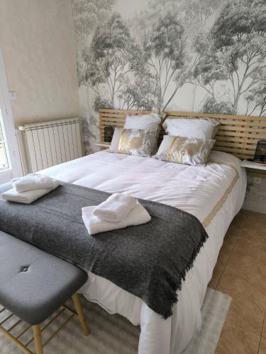 a bedroom with a large white bed and a chair at la maison de Gaston in Rix
