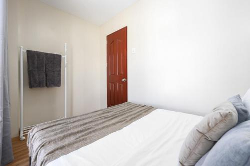 a bedroom with a white bed and a brown door at Furnished 3BR Townhouse Near Cebu IT Park with Parking, Fast WiFi, Netflix and More in Cebu City
