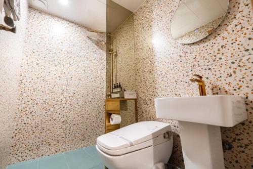 a bathroom with a white toilet and a sink at Hotel Ippda Wonju in Wonju