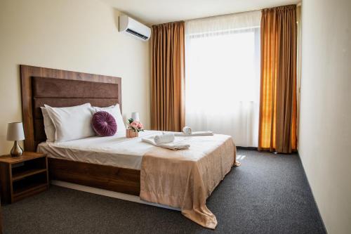 Family Suite One-Bedroom with Kitchen في ساينت قسطنطين وهيلينا: غرفة نوم بسرير كبير مع نافذة كبيرة