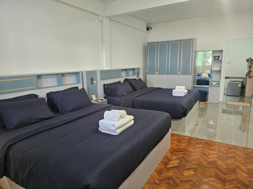 Un dormitorio con dos camas con toallas encima. en Middletown chiangmai 2king bed, en Chiang Mai