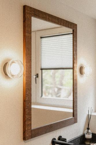 a mirror in a bathroom with a window at de Wever Lodge in Otterlo