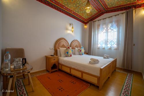 a bedroom with a bed with a coffered ceiling at Riad ALHAMBRA in Chefchaouene