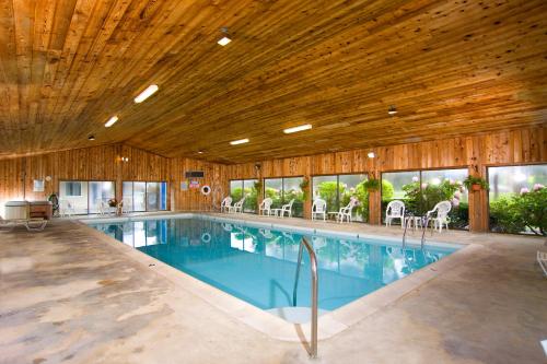 a swimming pool in a building with a wooden ceiling at Southfleet Motor Inn in Wellfleet