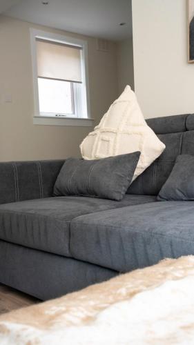 a gray couch in a living room with a window at Graham House in Livingston