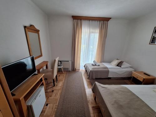 a hotel room with two beds and a flat screen tv at Villa Una in Bihać