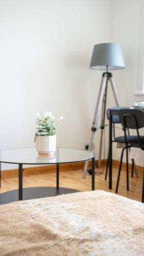 a living room with a table and a plant on a tripod at Deanswood House in Livingston