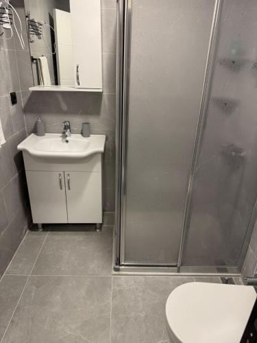 a bathroom with a shower and a sink and a toilet at Uyar Pansiyon & Apart in Bodrum City