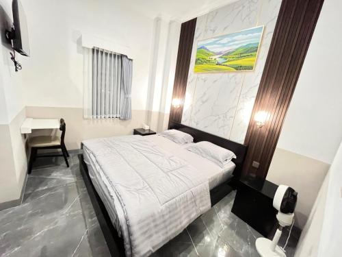 a bedroom with a bed and a desk in it at wendy syariah mansion in Gandul
