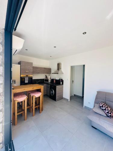 une cuisine et un salon avec une table et un canapé dans l'établissement N4 Maison T2 climatisé, à Ajaccio