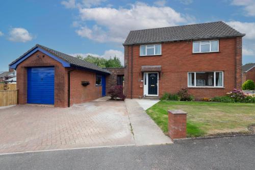 a red brick house with a blue garage at Corner House in Wellington