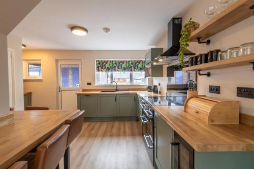 a kitchen with green cabinets and wooden counter tops at Corner House in Wellington