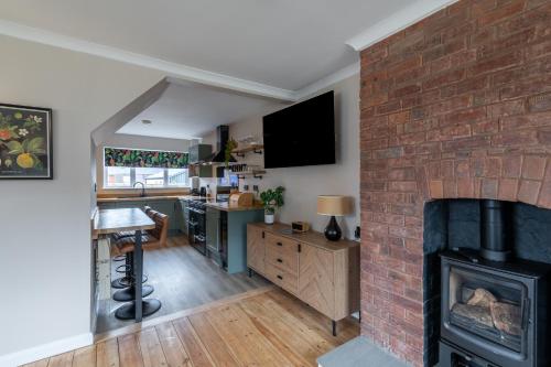 a living room with a fireplace and a brick wall at Corner House in Wellington