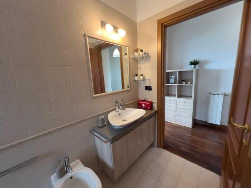 a bathroom with a sink and a toilet and a mirror at Next Stop Fiumicino FCO Airport e Fiera di Roma in Fiumicino Airport