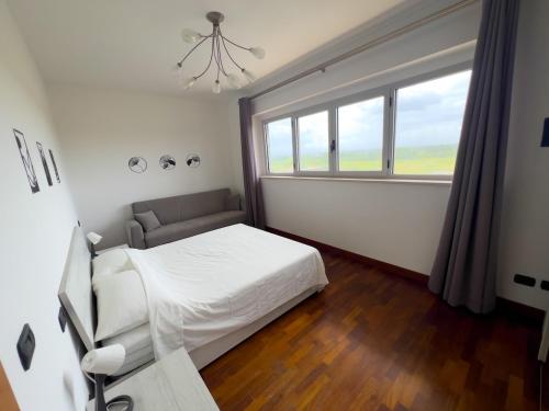 a bedroom with a bed and a chair and a window at Next Stop Fiumicino FCO Airport e Fiera di Roma in Fiumicino Airport