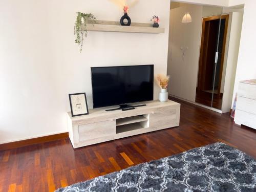 a living room with a flat screen tv on a entertainment center at Next Stop Fiumicino FCO Airport e Fiera di Roma in Fiumicino Airport