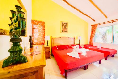 a bedroom with two beds with red sheets at Playacar - Executive Budget Room With Swimming Pool Air Conditioning and Parking in Playa del Carmen