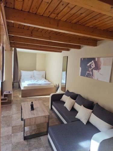 una sala de estar con un sofá y una cama en Downtown Apartman - Friends, en Győr