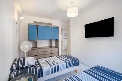 une chambre avec deux lits et une télévision à écran plat dans l'établissement Evasion Cannoise, à Cannes